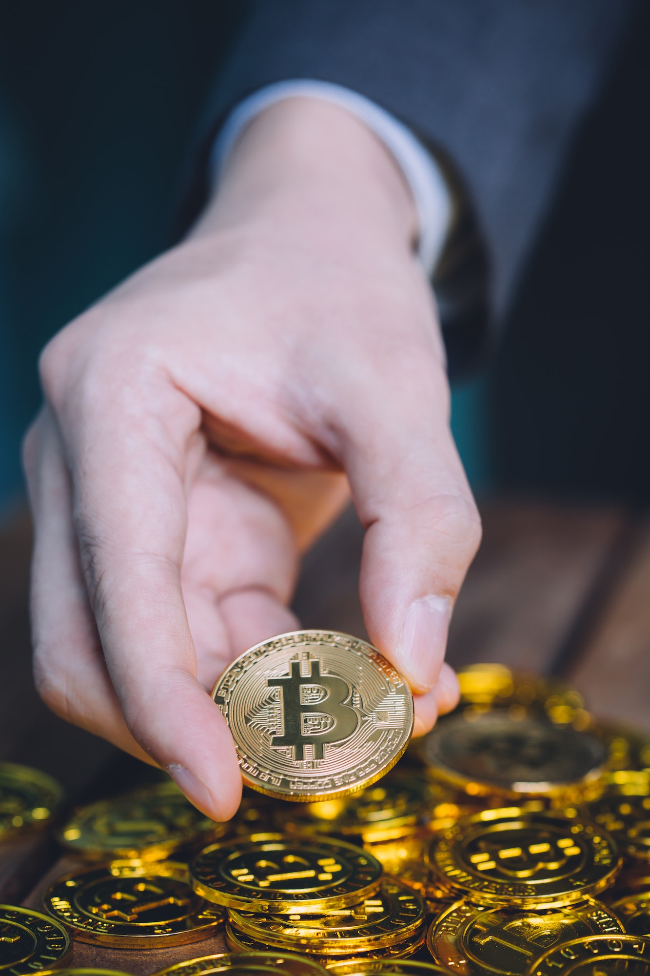 businessman counting and holding bitcoin sign of coins - vertical image